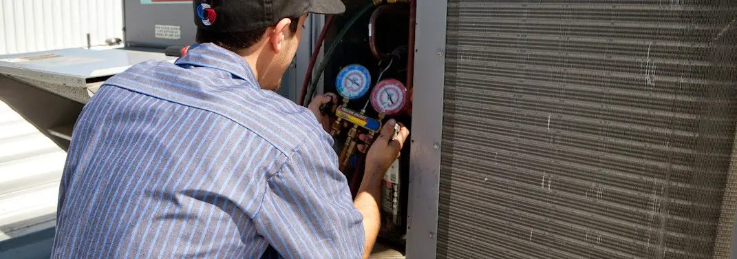 HVAC technician servicing a condenser unit in Lakeside