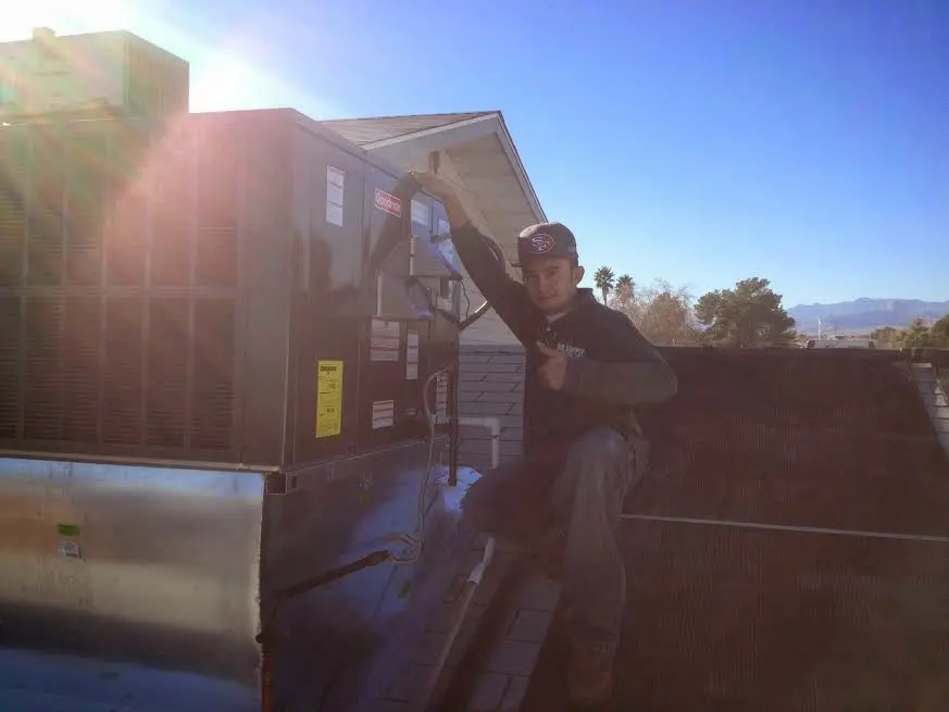 HVAC technician performing Air Duct Cleaning on a rooftop unit in Lakeside